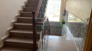 a staircase in a house with a glass railing at Rudram Hotel Yoga & Ayurveda Retreat in Rishīkesh