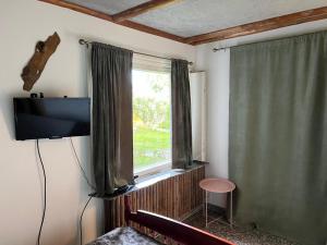 a room with a television and a window with a stool at Fabulous 2 Bedroom Apartment in Vaasa