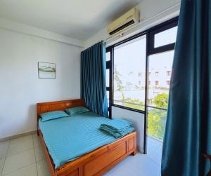 een slaapkamer met een bed en een groot raam bij Nhà Nghỉ FAMI in Ho Chi Minh-stad
