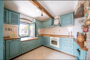 a kitchen with blue cabinets and a sink and a stove at Villa Mara Lustica Bay Retreat near Kotor, Tivat in Tivat