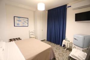 pokój hotelowy z łóżkiem i telewizorem w obiekcie B&B villamariascauri w mieście Scauri