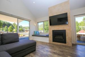 Una sala de estar con chimenea y televisión. en Amber Mist Villa - One, en Bright