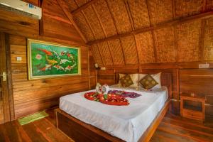 une chambre avec un lit dans une pièce en bois dans l'établissement Kubu Sental Cottage, à Nusa Penida