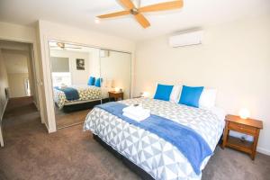 Un dormitorio con una cama grande con almohadas azules. en Amber Mist Villa - One, en Bright
