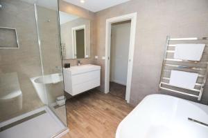Un baño con lavabo y ducha de cristal. en Amber Mist Villa - One, en Bright 17 fotos más