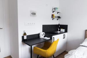 a small kitchen with a table and a yellow chair at Lemon drop in Brno +17 photos