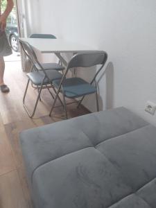 a table and chairs in a room with a couch at Pansion Panonika 2 in Tuzla