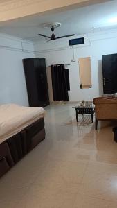a room with a bed and a couch and a table at Shanti Sadan Homestay in Rājgarh
