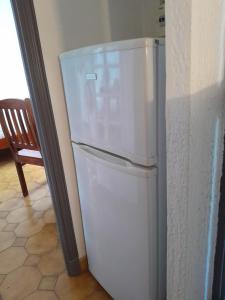 a white refrigerator in a kitchen with a chair at Beauty in Saint-Jean-Cap-Ferrat