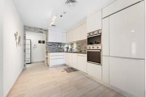 a kitchen with white cabinets and white appliances at 76th floor- 2 BR apartment Princess Tower PalmView in Dubai