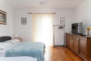 a bedroom with a bed and a flat screen tv at Apartment Matic Sonkovic in Skradin