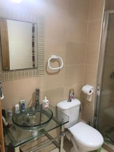 アシラにあるAppartement 2 chambres vue piscine - Marina Golf Asilahのバスルーム(トイレ、ガラスの洗面台付)