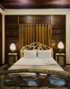 a bedroom with a large bed with two lamps at Sigiri Vananthara in Sigiriya