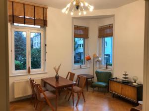 a living room with a table and chairs and windows at Stylische Mid-Century-Wohnung im Zentrum Plauens in Plauen