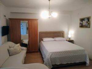 a small bedroom with a bed and a couch at Pelivan Apartments in Kaštela +65 photos