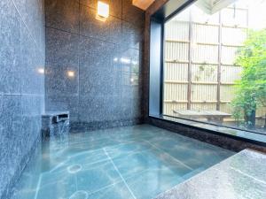 a bathroom with a tub with a window and a shower at Tabist TOKYO CITY VIEW HOTEL in Tokyo