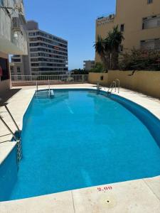 a large blue swimming pool on top of a building at Casa Dalia - One bedroom flat in Torremolinos