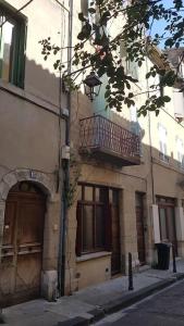 a building with a balcony on the side of a street at Studio en plein centre Valence in Valence