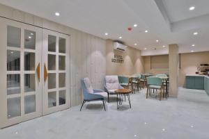 a waiting room with a row of chairs and tables at Hotel Serenity in Ahmedabad