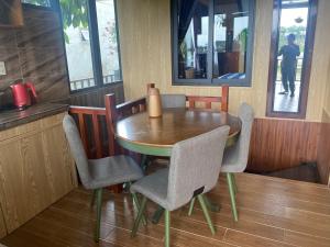 Malá home & coffee في دالات: طاولة طعام مع كراسي وطاولة خشبية