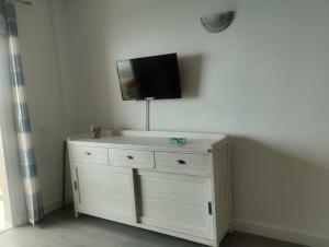 eine weiße Kommode mit einem Flachbild-TV an der Wand in der Unterkunft Primera linea playa, vista espectacular in El Médano