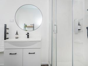 a bathroom with a sink and a mirror at Valley Hideaway - Kūaotunu Holiday Cabin in Kuaotunu +12 photos