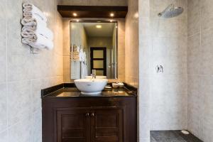 a bathroom with a sink and a mirror at Phuket Pool Residence - SHA Extra Plus in Rawai Beach