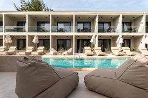 a hotel with a swimming pool with lounge chairs at Thera luxury living in Nikiti