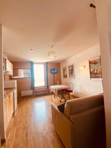 a living room with a couch and a table at Les Edelweiss " les Balcons de Recoin" in Chamrousse
