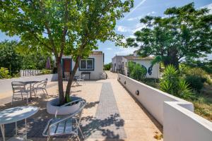 un patio con tavoli, sedie e un albero di Casa da Eira - Quinta do Mestre a Tavira