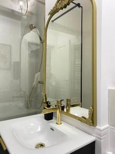 a bathroom with a gold sink and a mirror at Studio Luxury Black & White in Alba Iulia
