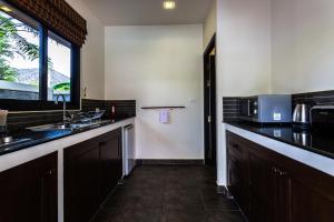Phuket Pool Residence - Adults only في شاطئ راوايْ: مطبخ مع حوض وميكروويف