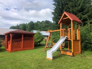 a wooden playground with a slide and a gazebo at Zielony Zakątek in Łubno