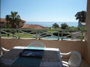 a table with a laptop on top of a balcony at Studio Cala Sognu Moriani residence in San-Nicolao