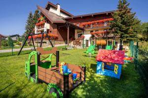 a yard with playground equipment in front of a house at Villa Gloria Rooms & Apartments in Donovaly