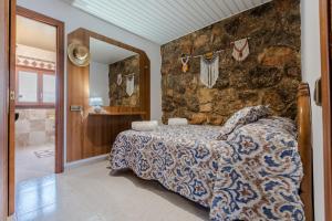 a bedroom with a bed and a stone wall at Villa Rural Avril in Camarles +138 photos