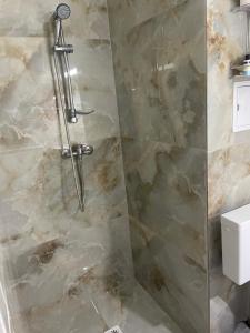 eine Dusche in einem Badezimmer mit einer Steinwand in der Unterkunft Luxury Beta in Mangalia + 28 Fotos