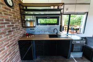 a kitchen with a sink and a brick wall at WUDINO - Ubytování v přírodě, se zvířaty v industriálním duchu, in Ostrov u Macochy
