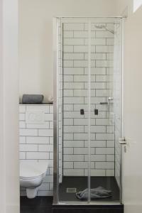 a glass shower in a bathroom with a toilet at Frühstückshotel Fürstenwerth in Wilhelmshaven +76 photos