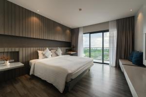 a bedroom with a large bed and a large window at Hotel IKON Phuket - SHA Extra Plus in Karon Beach
