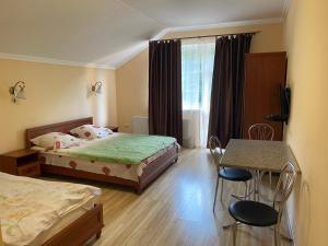 a bedroom with two beds and a table and chairs at Rika House in Sinyak