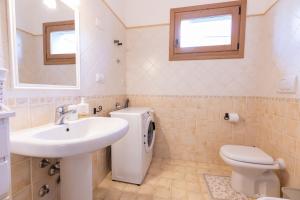 Un baño con lavabo, inodoro y espejo. en Casa Giulia - vacanze a Olbia, en Olbia