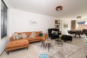 ein Wohnzimmer mit Sofa und Tisch in der Unterkunft Villa Mater Maris - with large garden and garage in Middelkerke