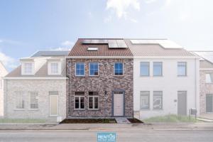 a large brick house with solar panels on the roof at Villa Mater Maris - with large garden and garage in Middelkerke