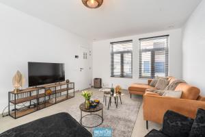 ein Wohnzimmer mit zwei Sofas und einem Flachbildfernseher in der Unterkunft Villa Mater Maris - with large garden and garage in Middelkerke