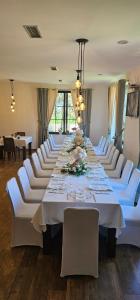 a large dining room with a long table with white chairs at Green Park Divjake in Divjakë