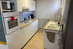 una piccola cucina con lavello e microonde di Bel appartement en cœur de ville a Agen