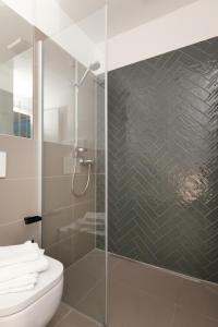 a bathroom with a glass shower with a toilet at Brera Leipzig in Leipzig