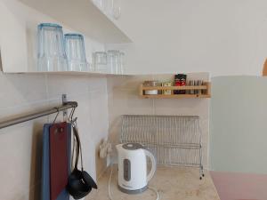 テルアビブにあるZuzu Studio apartmentsのガラスの食器が置かれた棚のある小さなキッチン