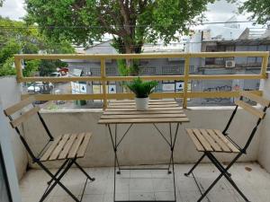 テルアビブにあるZuzu Studio apartmentsのバルコニーに木製のテーブルと椅子2脚